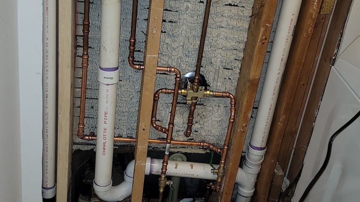 Copper and PVC repipe work in a Hampton Roads home laundry wall.