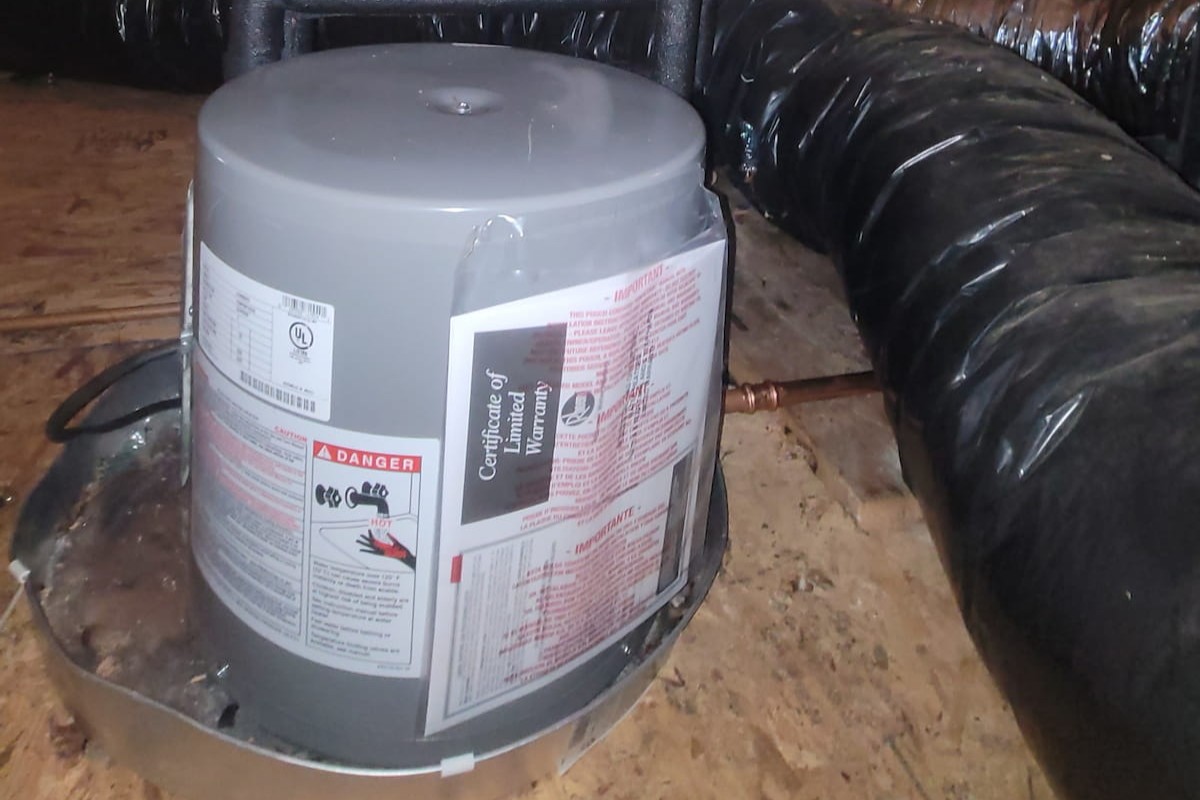 New water heater installation with drip pan by Apex Facility Services.